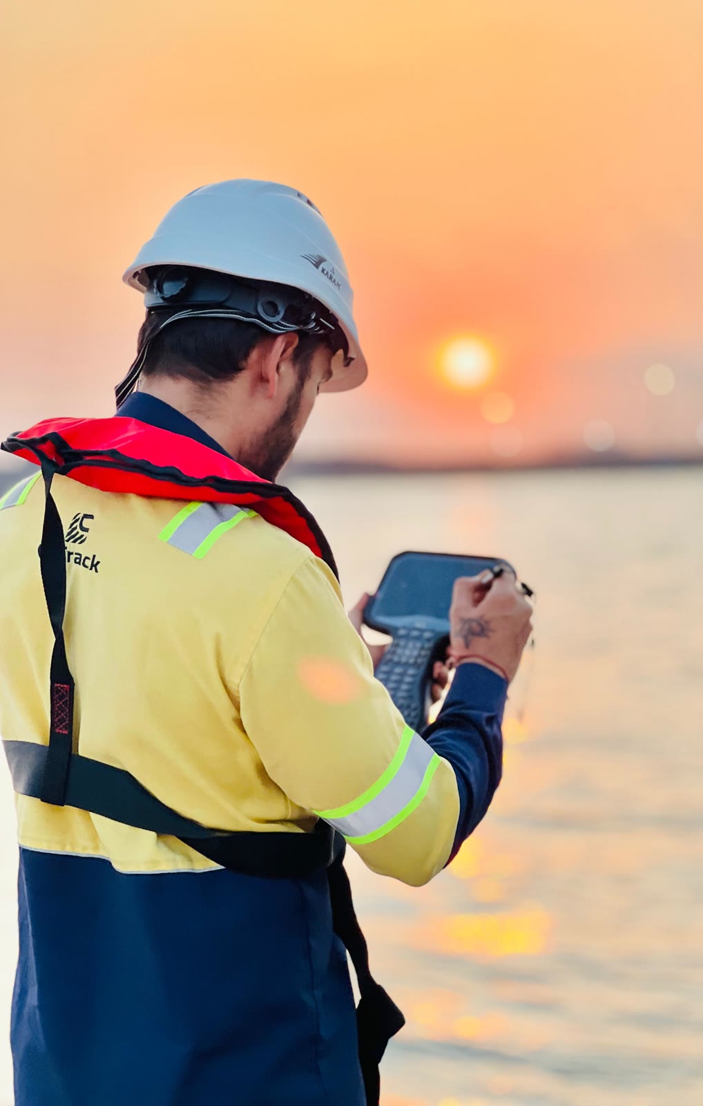 C-TRACK surveyor using a GNSS field controller at sunset