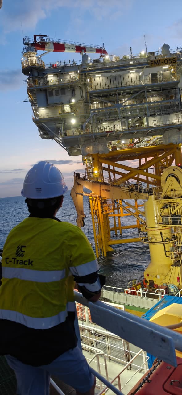 C-TRACK surveyor on deck beside an offshore substation platform at dusk