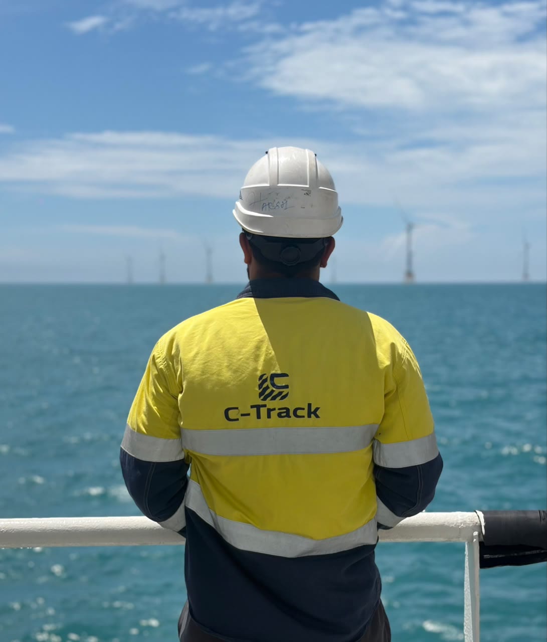 C-TRACK crew member on deck looking out at an offshore wind farm